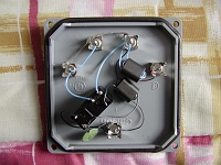  The inside of one of the direction reversing boxes.  The big black box is a relay, and there is a 2:1 transformer to match to the feedline, and a 1;1 transformer to invert the phase of the western vertical.  The capacitor bypasses RF around the relay coil.  The 1:1 transformer also decouples DC from the RF.